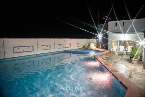 La alberca y la terraza de noche · Hotel Aqua Inn