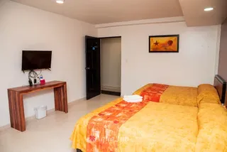 Escritorio con televisión frente a las camas · Hotel Aqua Inn
